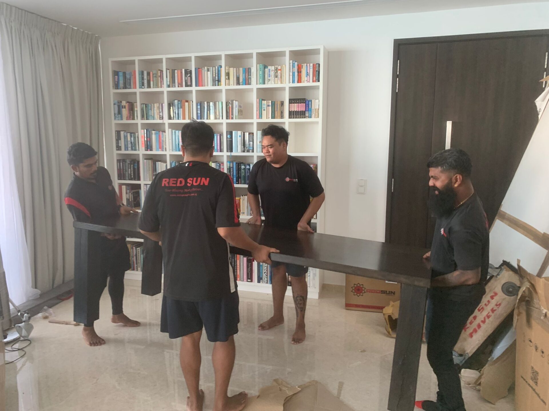 Furniture movers transporting table during relocation in Tampines