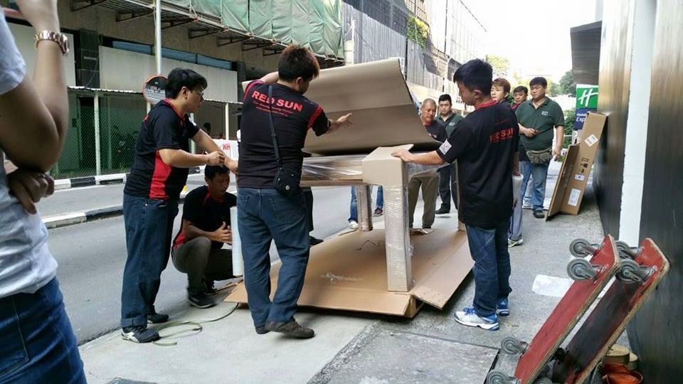 Jurong movers Singapore packing and securing large office furniture for relocation